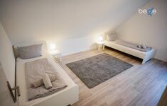 Schlafzimmer 2 mit zwei Einzelbetten und Sitzecke mit Smart TV