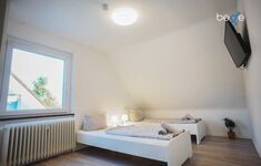 Schlafzimmer 3 mit zwei Einzelbetten und Sitzecke mit Smart TV