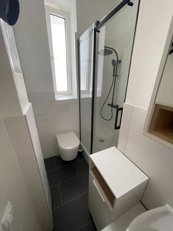 Modernes Bad mit Dusche, Toilette und Waschbecken