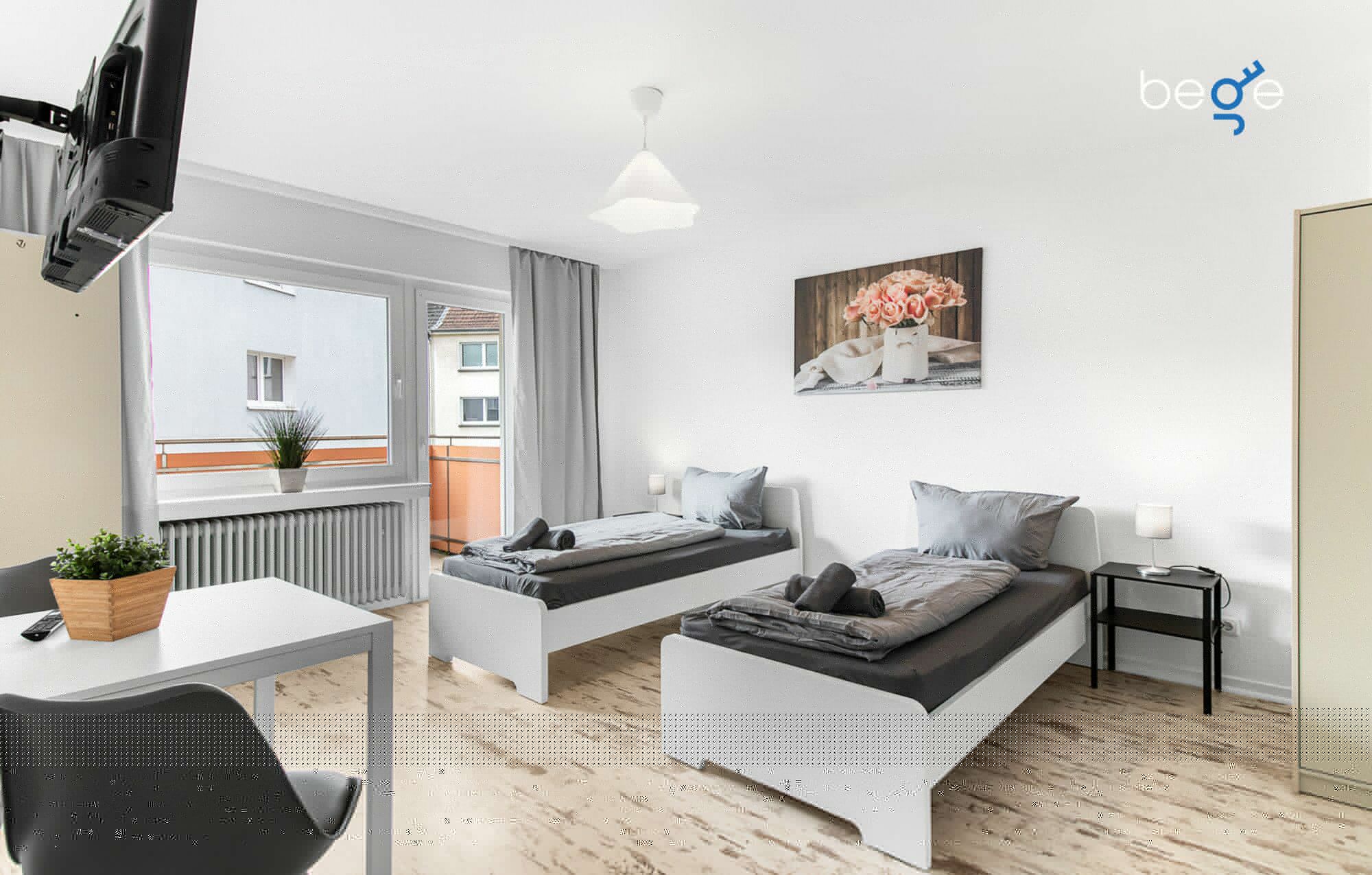 Schlafzimmer 1 mit zwei Einzelbetten, Sitzecke und Smart TV 