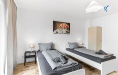Schlafzimmer 1 mit zwei Einzelbetten, Sitzecke und Smart TV 