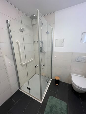 Das moderne Badezimmer überzeugt mit einer bodengleichen Dusche für maximalen Komfort.