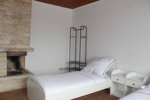 Schlafzimmer 2 mit 2 Einzelbetten und Kamindeko