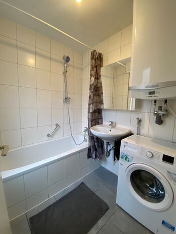 Badezimmer mit Badewanne und Waschmaschine