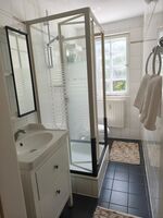 Badezimmer mit Dusche, WC und Fenster 