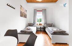 Schlafzimmer 2 mit zwei Einzelbetten, Sitzecke und Smart TV