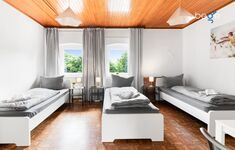 Schlafzimmer 1 mit drei Einzelbetten, Sitzecke und Smart TV