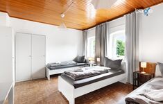Schlafzimmer 1 mit drei Einzelbetten, Sitzecke und Smart TV