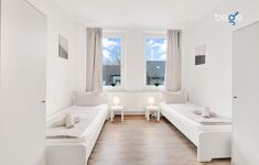 Schlafzimmer 1 mit zwei Einzelbetten, Sitzecke und Smart TV 