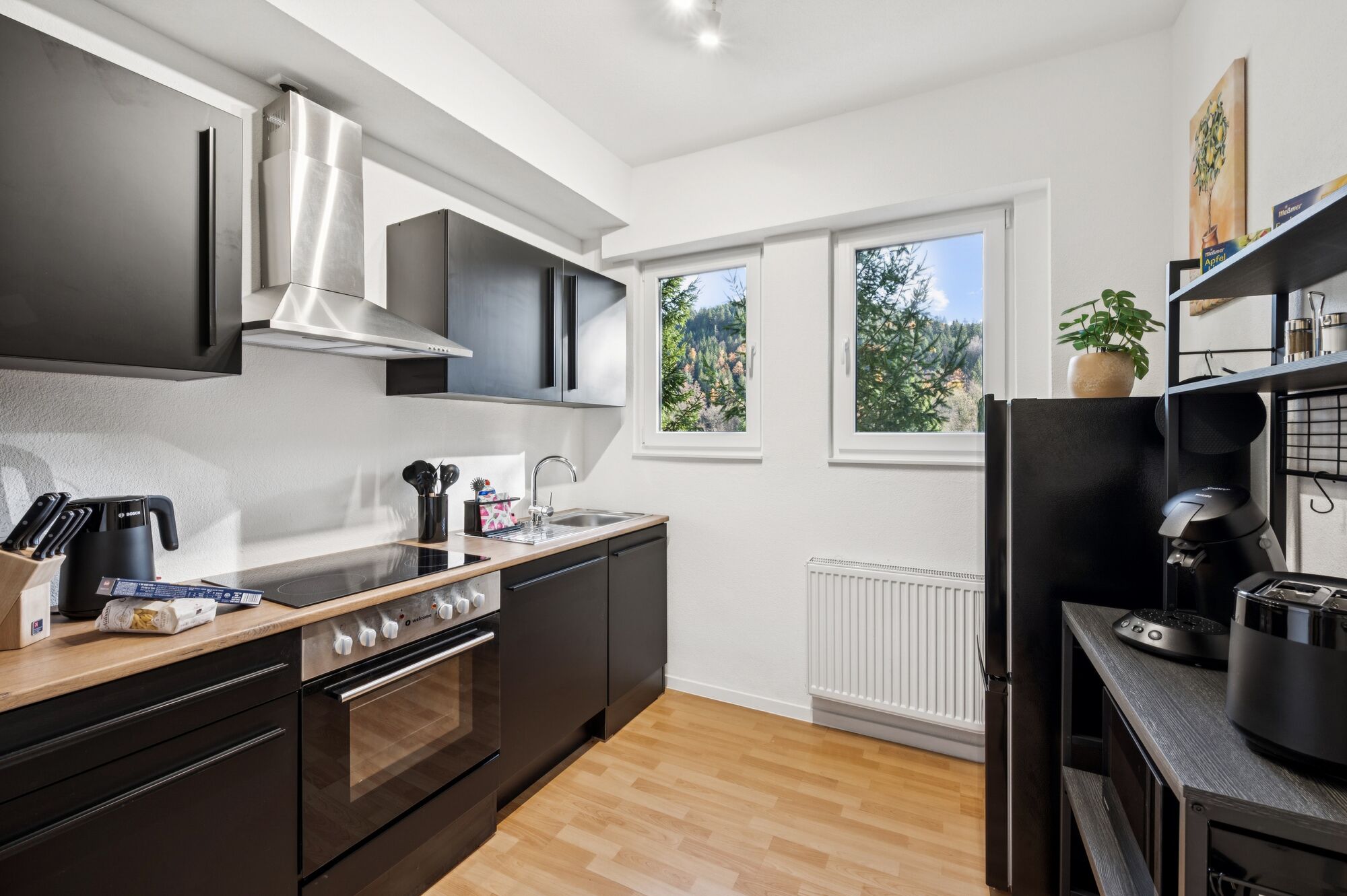 Voll ausgestattete, moderne Küche mit Blick ins Grüne.