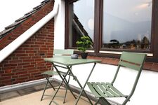 Gemütlicher Balkon mit Sitzgelegenheit Kleiner, ruhiger Balkon mit Tisch und zwei Stühlen