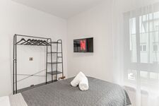 Schlafzimmer 2 mit zwei Boxspringbetten, Smart-TV und Kleiderständern.