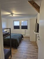 Schlafzimmer mit Doppelbett und Etagenbett, Schrank und TV