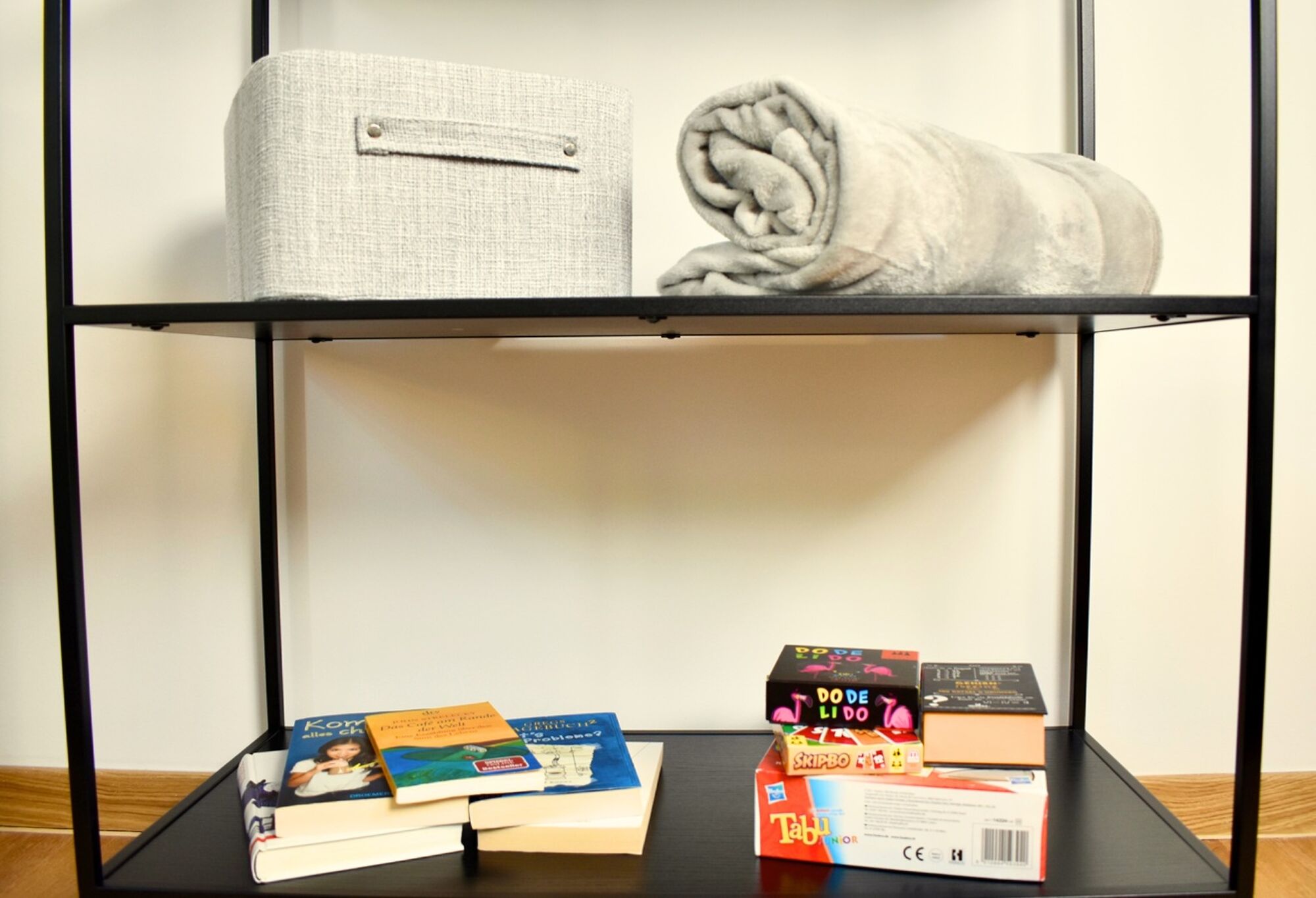 Zimmer 1: Auf diesem Foto habe ich euch einige Bücher und Spiele bereitgelegt, um gemeinsam gemütliche Stunden zu verbringen. So lässt sich der Abend wunderbar entspannt ausklingen und für schöne Erinnerungen sorgen.