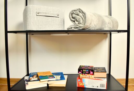 Zimmer 1: Auf diesem Foto habe ich euch einige Bücher und Spiele bereitgelegt, um gemeinsam gemütliche Stunden zu verbringen. So lässt sich der Abend wunderbar entspannt ausklingen und für schöne Erinnerungen sorgen.