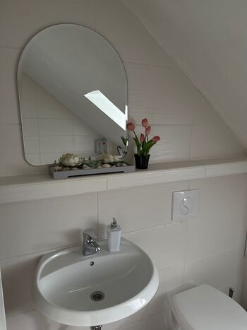 Badezimmer mit Waschmaschine und Badewanne 