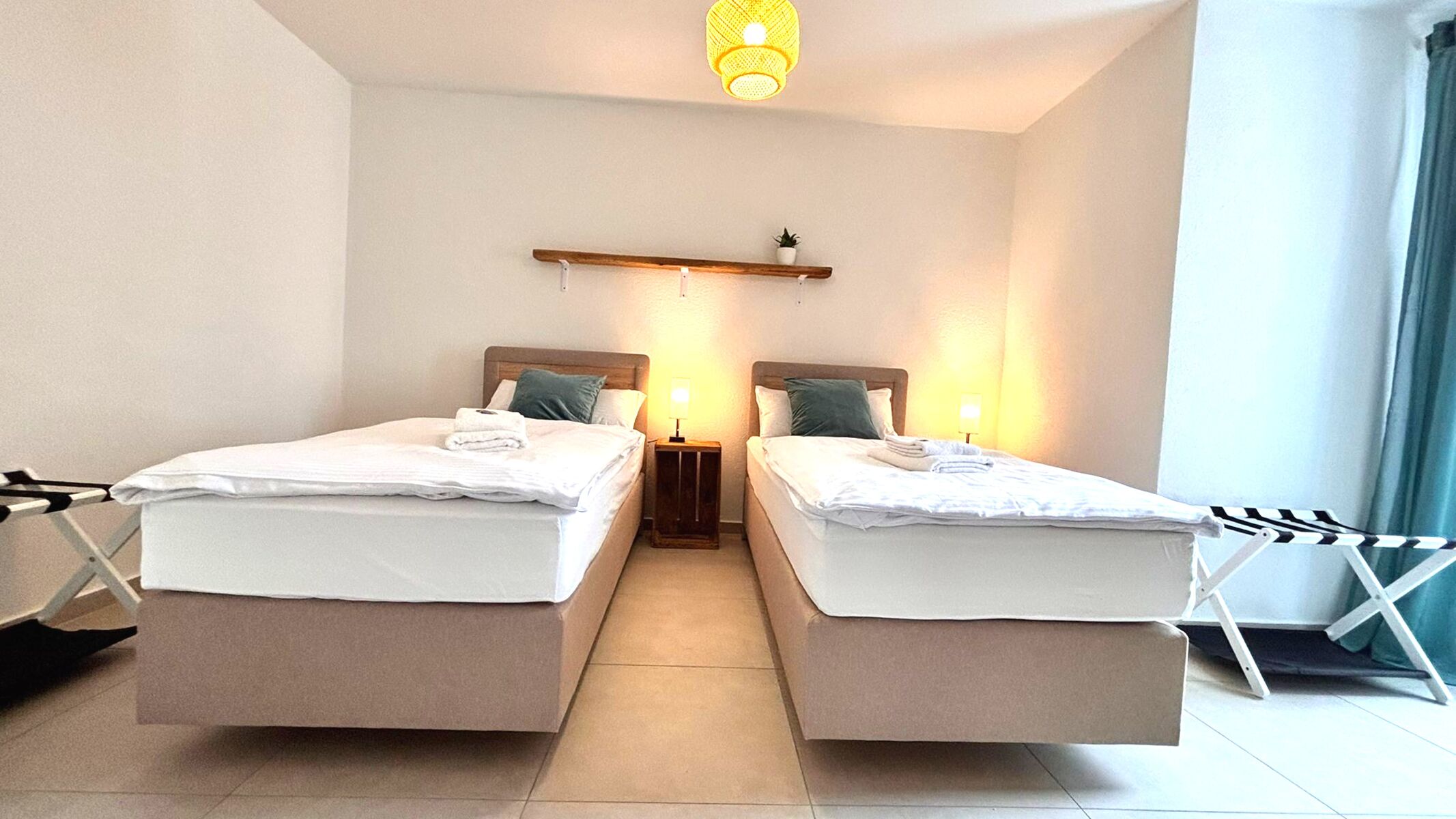 Gemütliches Doppelzimmer mit zwei Einzelbetten, stimmungsvoller Beleuchtung und Zugang zum Balkon. Helle Einrichtung, moderne Deko und ruhige Atmosphäre – perfekt zum Entspannen.