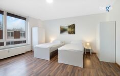 Schlafzimmer 1 mit zwei Einzelbetten, Sitzecke und Smart TV