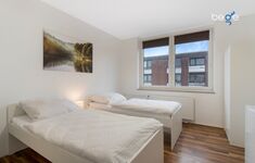 Schlafzimmer 2 mit zwei Einzelbetten, Sitzecke und Smart TV