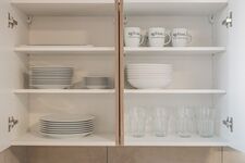 4-Zimmer-Wohnung: Voll ausgestattete Küche Große Küche mit Herd, Backofen, Mikrowelle, zwei Kühlschränken, Spülmaschine und Waschmaschine. Geschirr, Besteck, Töpfe und Pfannen vorhanden. Essbereich mit Tisch und Sitzplätzen.