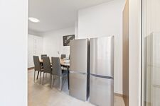 4-Zimmer-Wohnung: Voll ausgestattete Küche Große Küche mit Herd, Backofen, Mikrowelle, zwei Kühlschränken, Spülmaschine und Waschmaschine. Geschirr, Besteck, Töpfe und Pfannen vorhanden. Essbereich mit Tisch und Sitzplätzen.