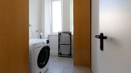 Extra im Ganz zum Apartment gehörendes Waschraum mit Waschmaschine und Trockner 
