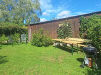 Liegewiese im Gemeinschaftsgarten mit Grillplatz und Biertischgarnitur